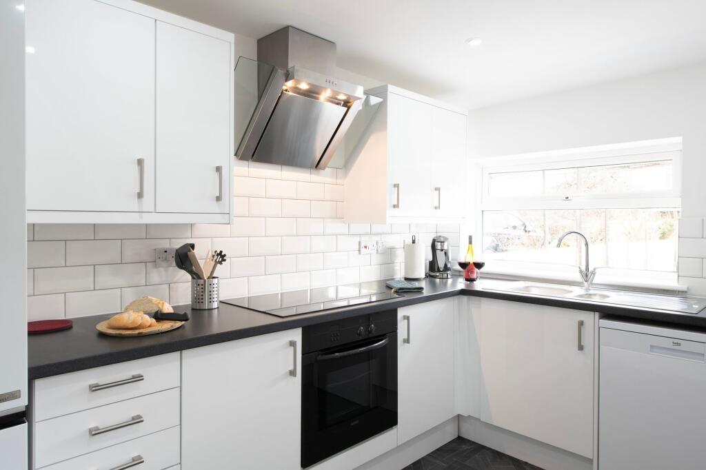 Bright and modern kitchen featuring sleek white...