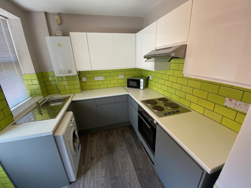 A bright and modern kitchenette with stylish gr...