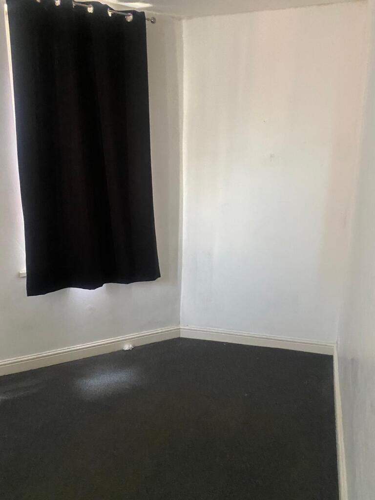 A small empty room with white walls and a black...