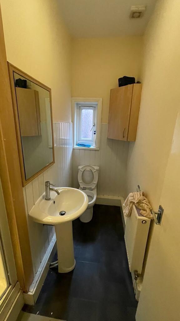 A compact and clean single toilet room featurin...