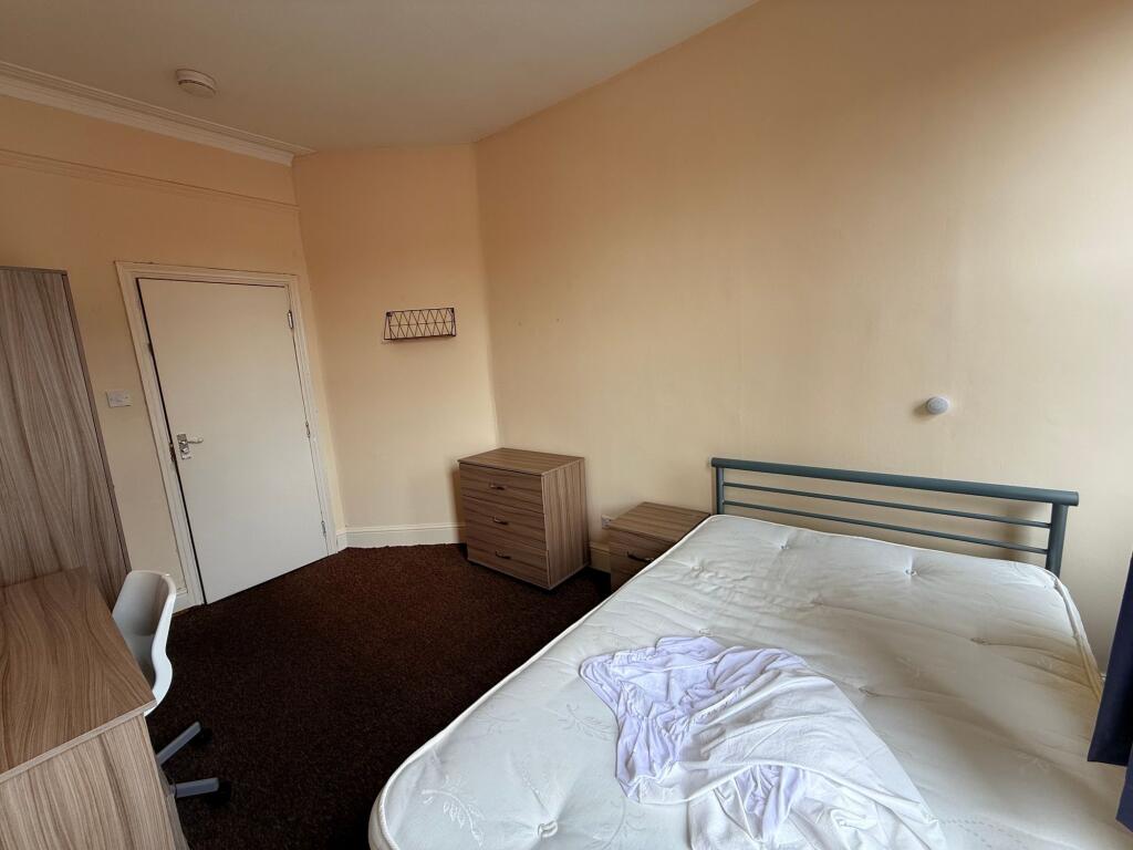 Bright, simply furnished bedroom with a double ...