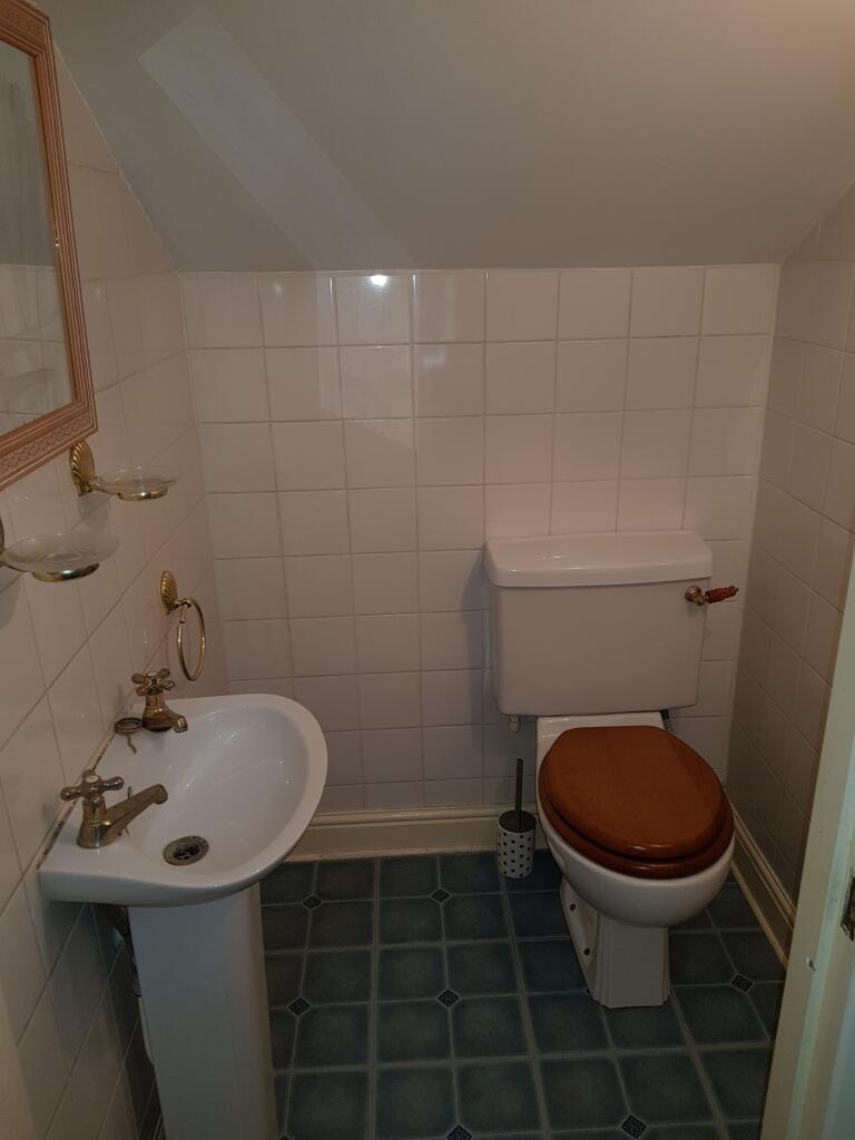 A tidy and functional single toilet with classi...