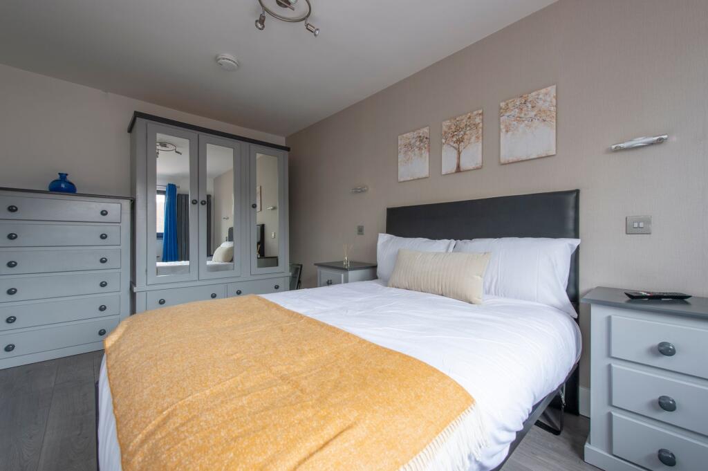 A bright and inviting master bedroom featuring ...