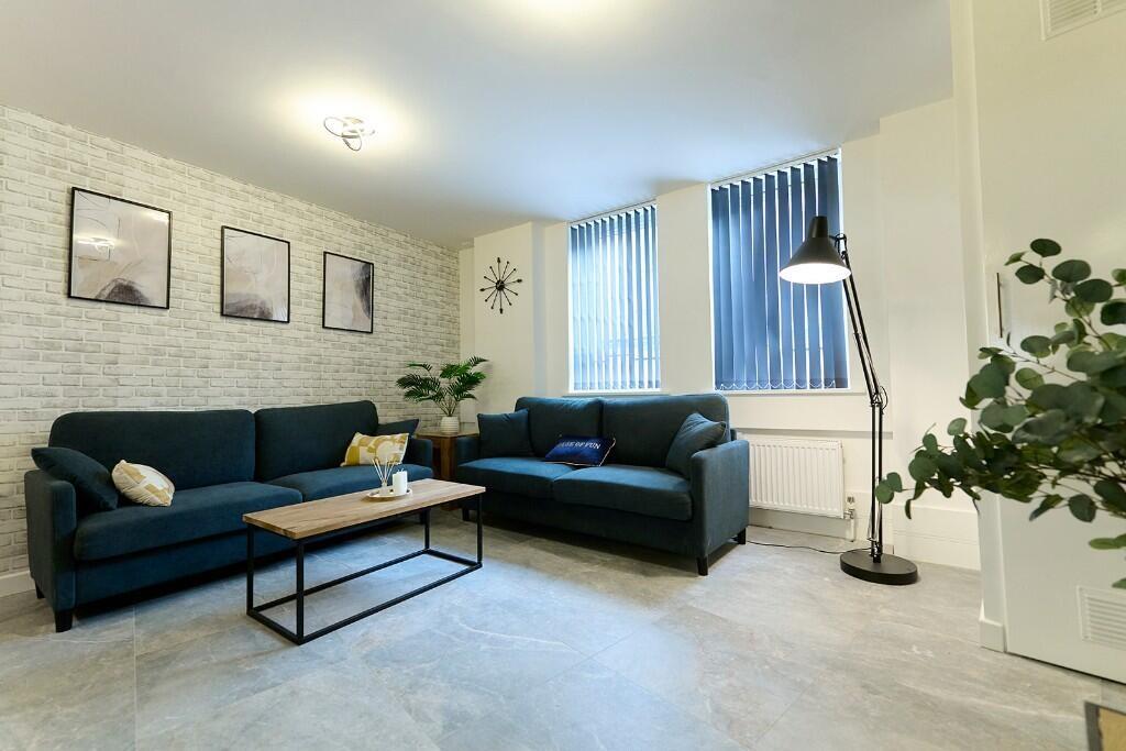 A bright and modern living room featuring two c...