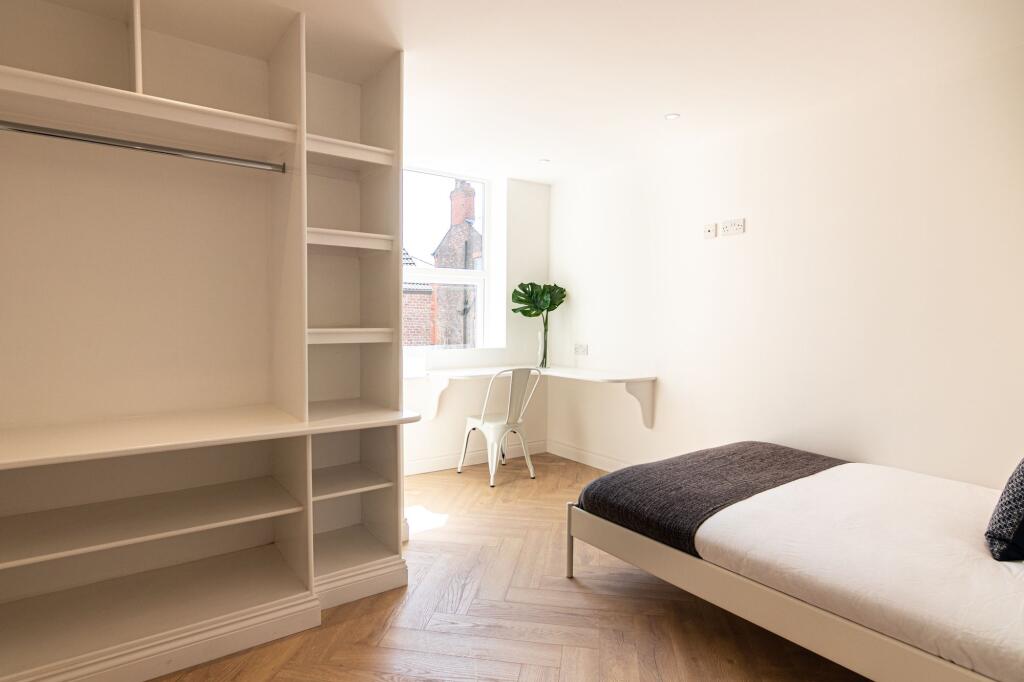 Bright and minimalist bedroom featuring a singl...