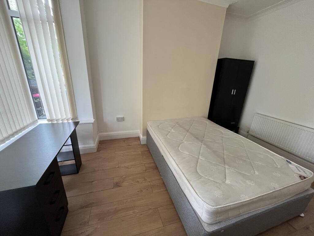 A bright and tidy single bedroom featuring a co...