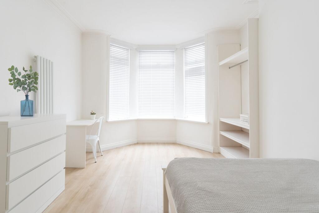 Bright and airy bedroom with large windows dres...