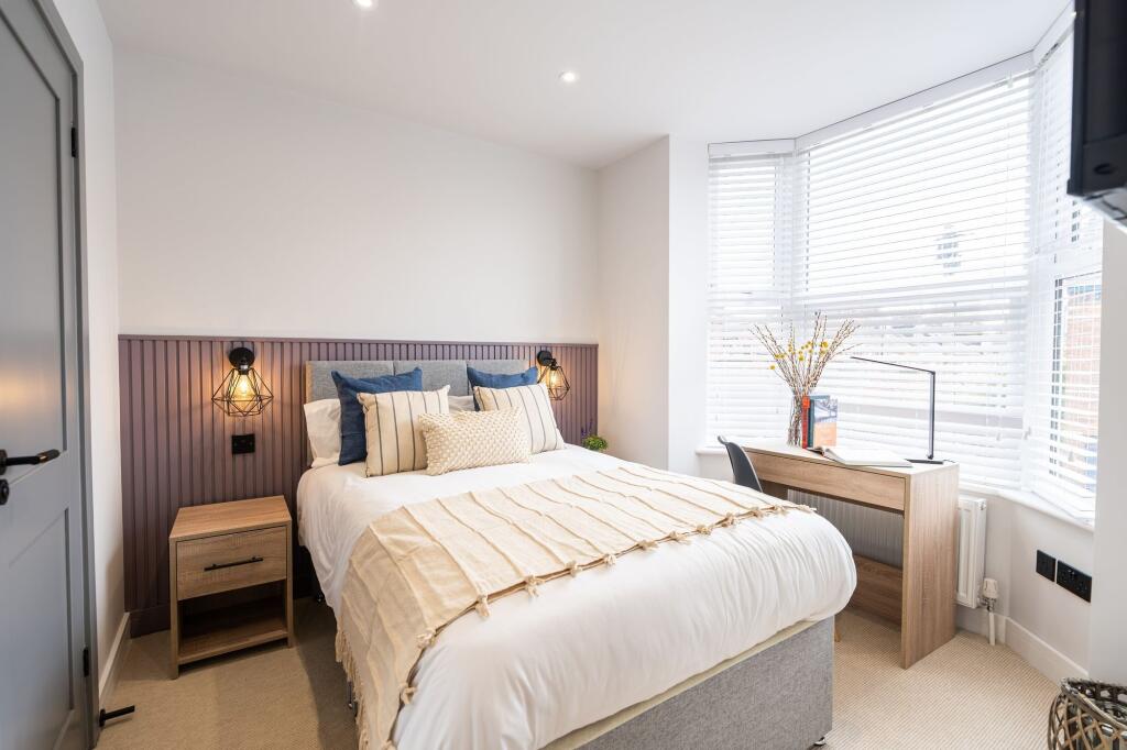 Bright and welcoming master bedroom featuring a...