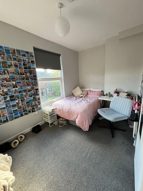 Bright, neatly kept bedroom featuring a comfy s...