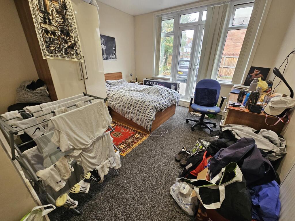 A spacious bedroom with a large bed, ample natu...