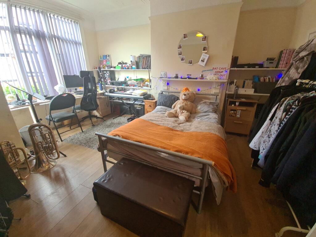 A cozy single bedroom featuring a comfortable b...