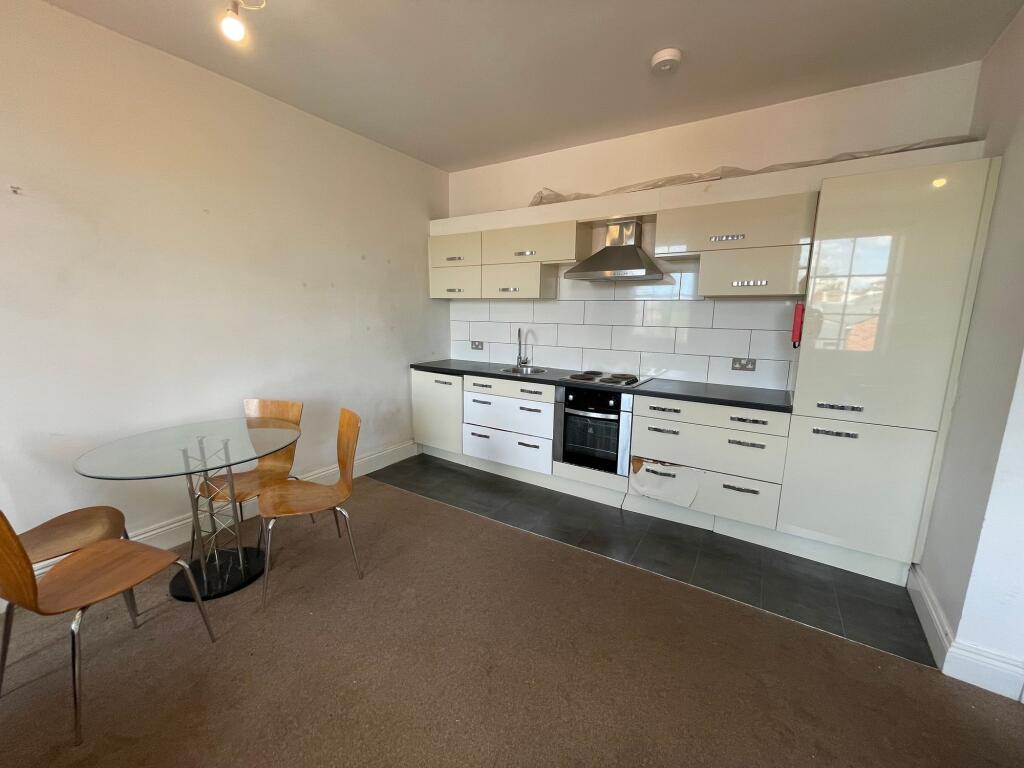 Bright kitchen area featuring modern cream cabi...