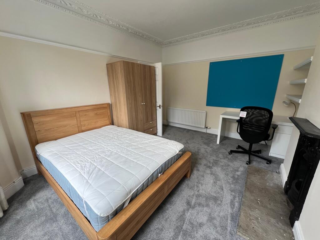 A spacious and well-lit double bedroom, perfect...