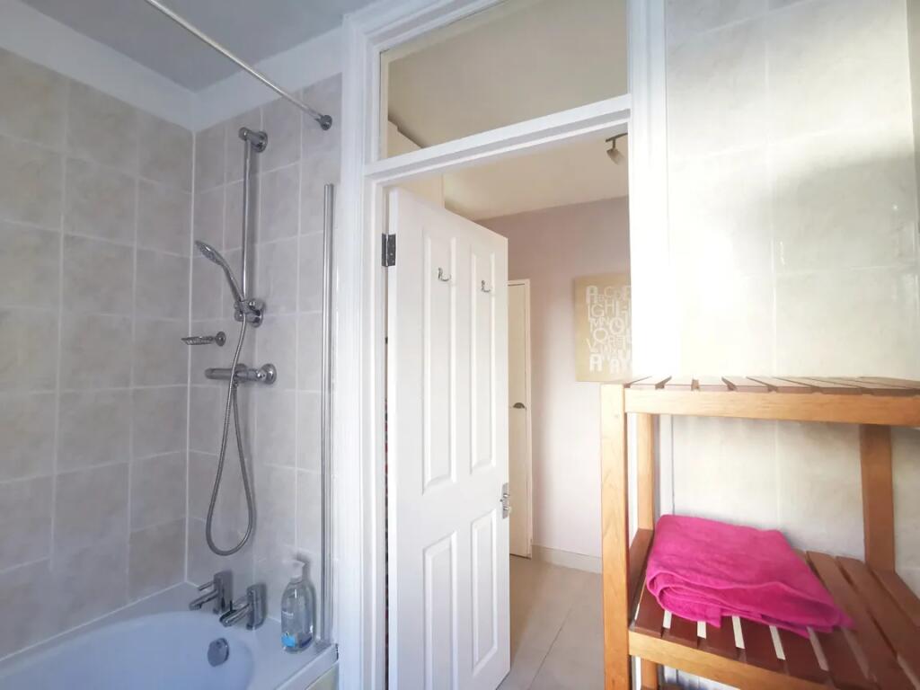 Bright and well-maintained bathroom suite featu...