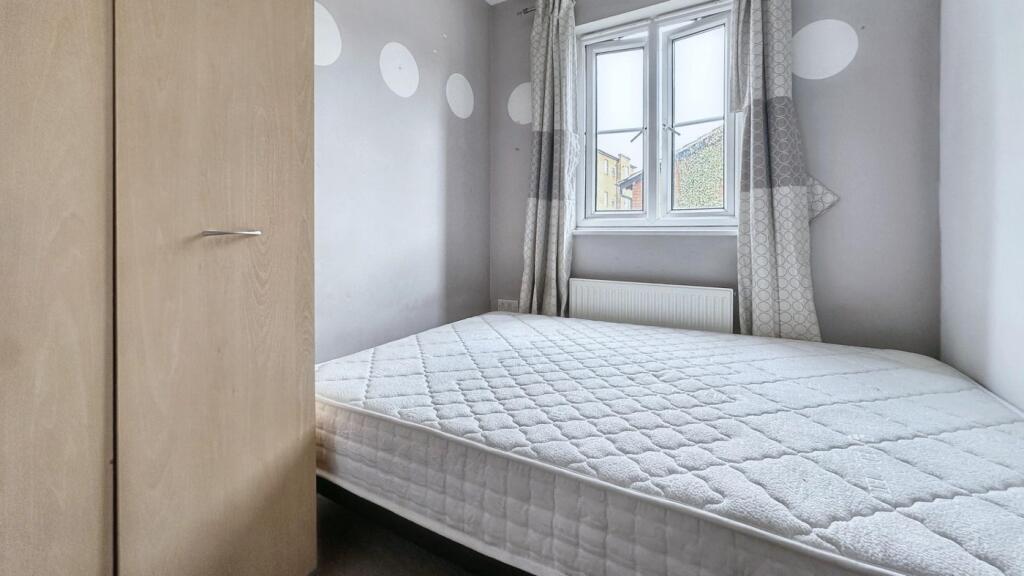 A tidy but small double bedroom with a bed and ...