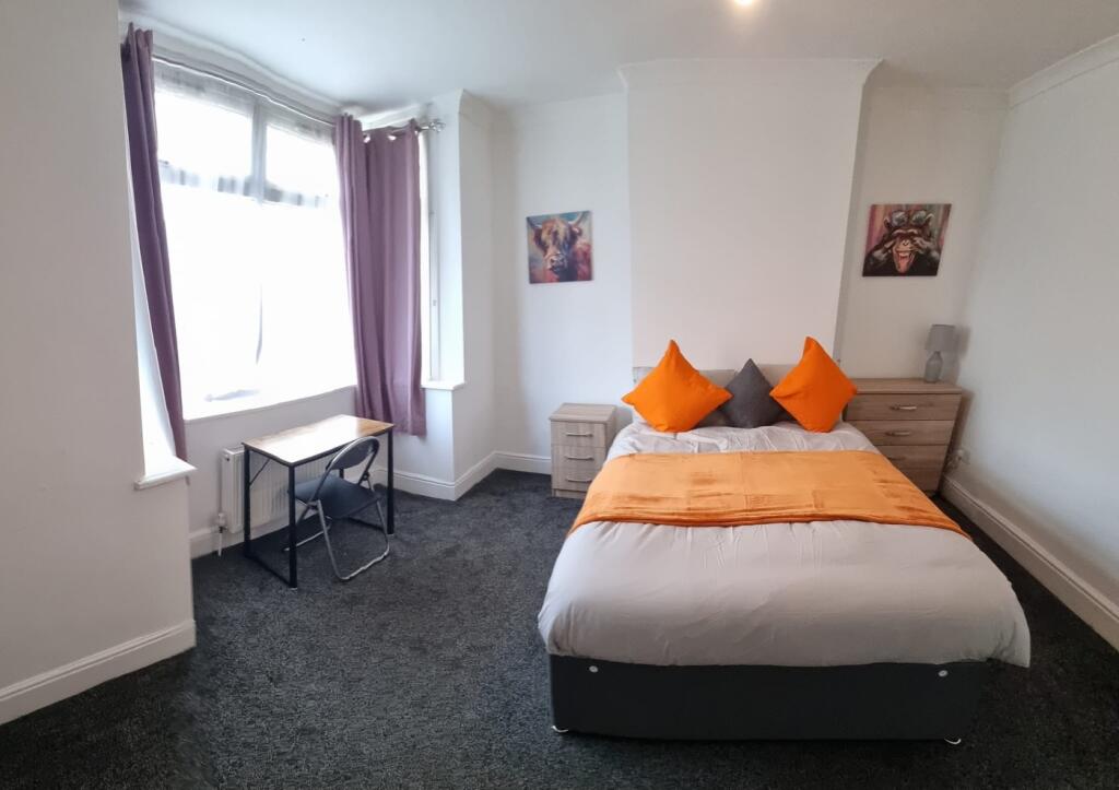 Spacious double bedroom featuring a comfortable...