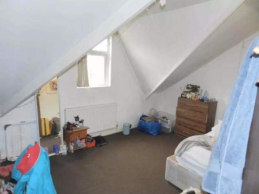 Cozy single bedroom featuring a sloped ceiling ...