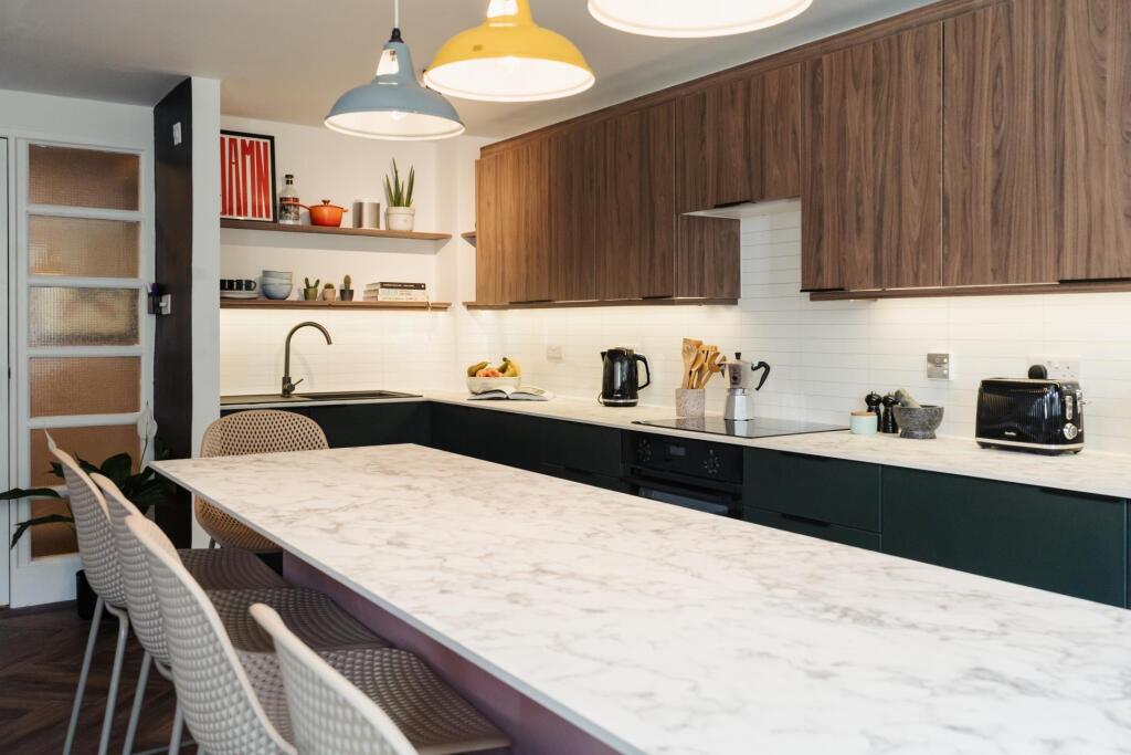 Modern and well-lit kitchen featuring a spaciou...