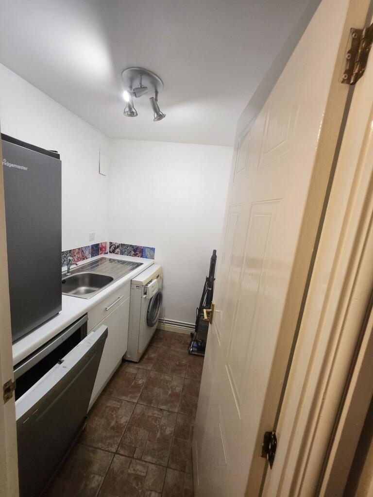 A compact kitchen area featuring a small sink, ...