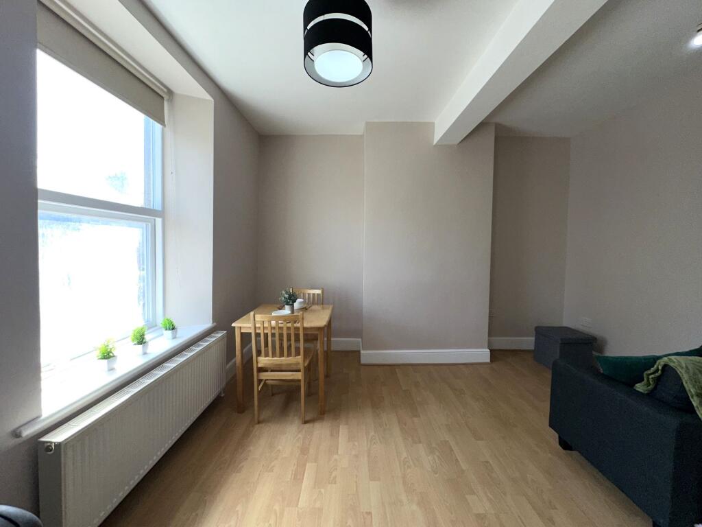 A bright and tidy living room featuring light w...