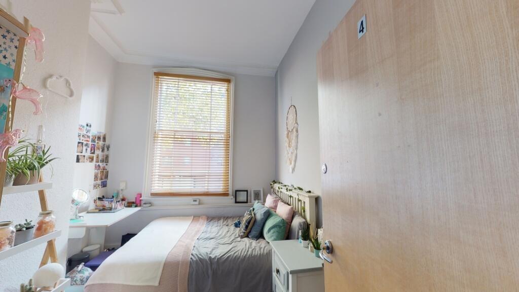 A bright and tidy double bedroom featuring a co...