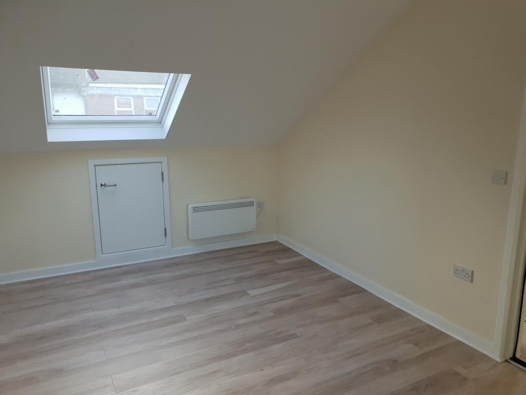 A clean and bright single bedroom featuring lig...