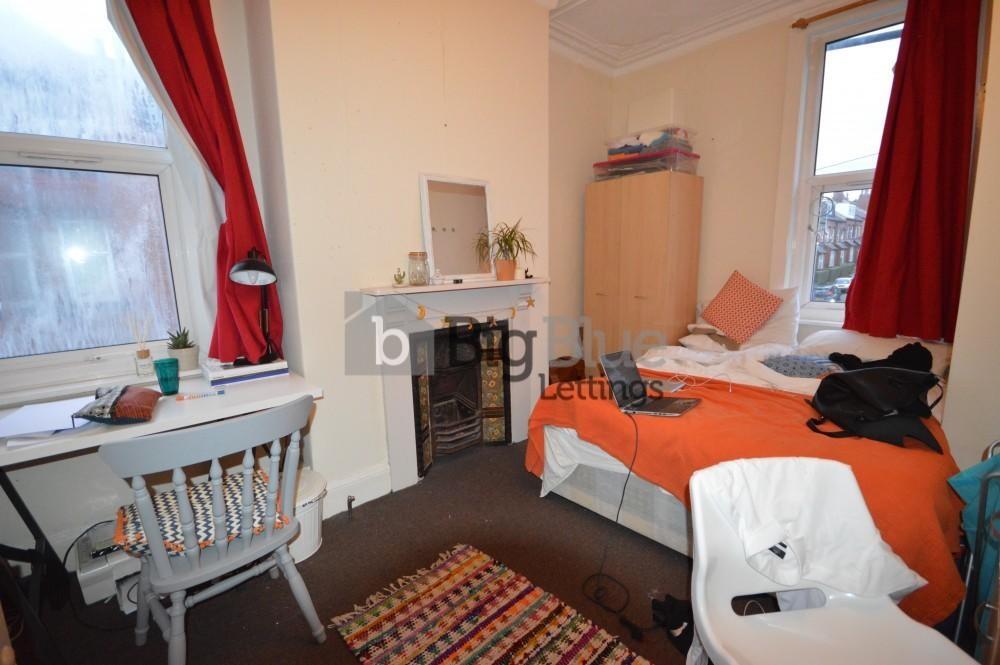 Cozy single bedroom featuring a comfortable bed...