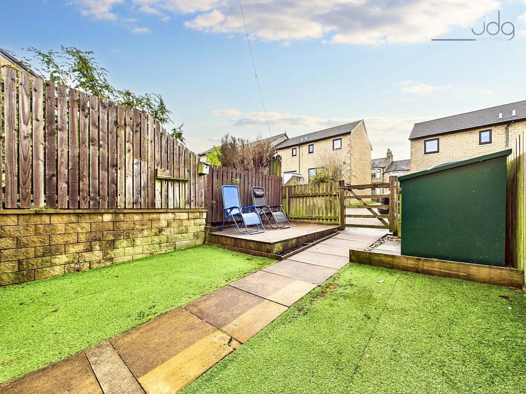 South-facing garden, designed for low maintenance, featuring artificial grass and a decked seating area