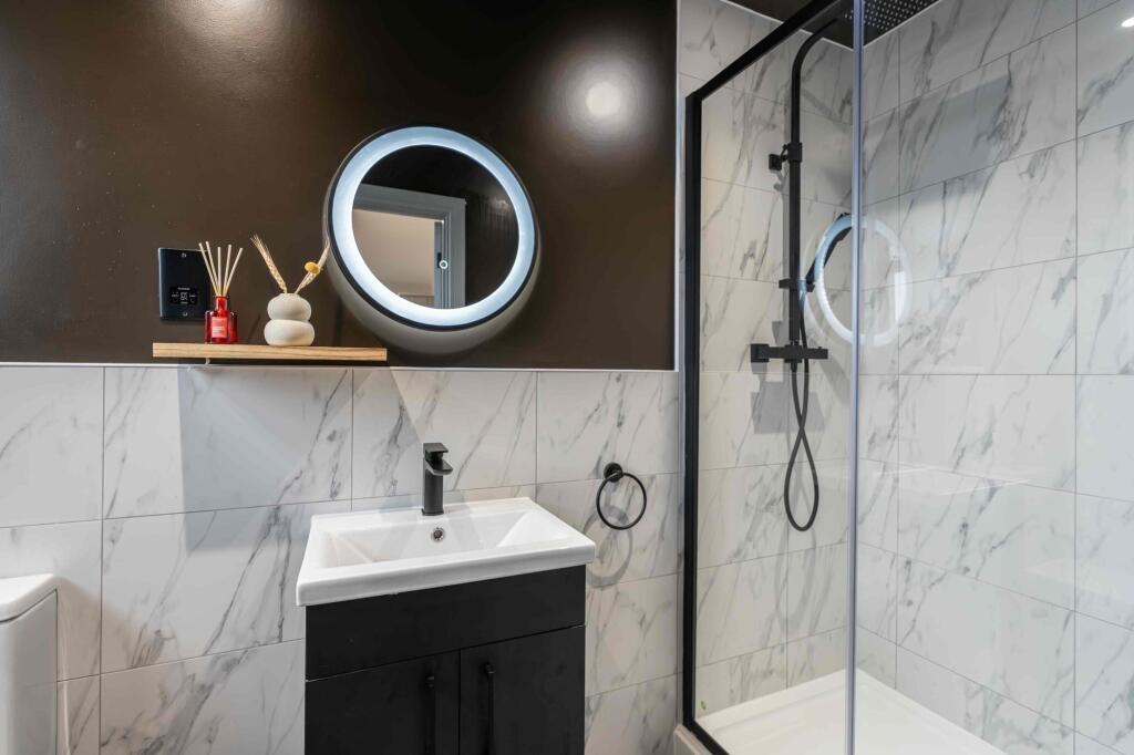 Modern bathroom featuring a stylish round illum...