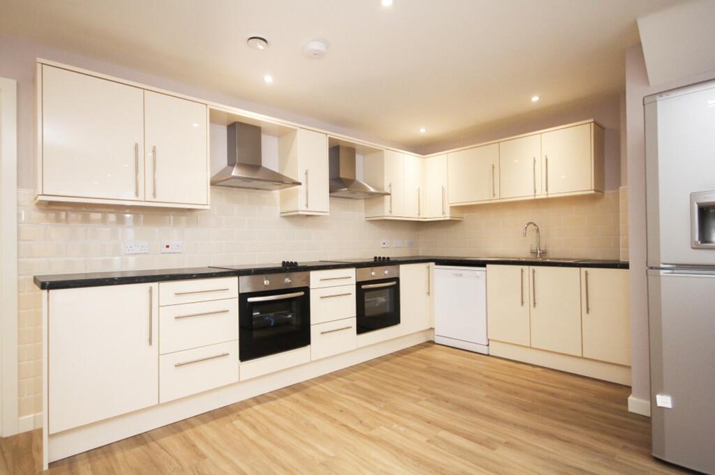 A spacious and modern kitchen featuring ample s...