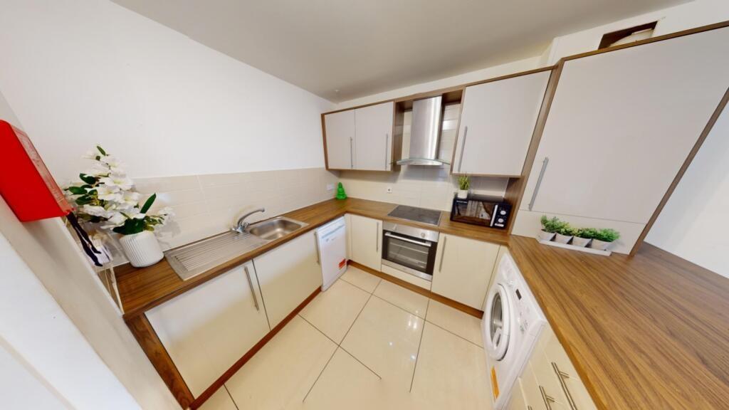 A modern and clean kitchen featuring white cabi...
