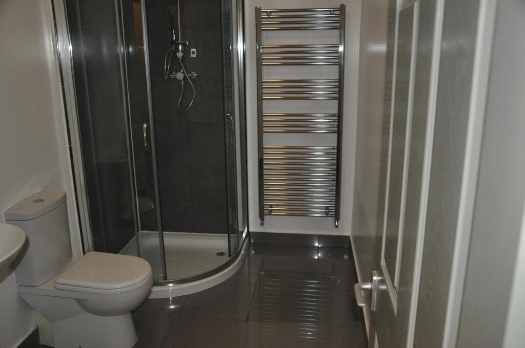 Modern bathroom featuring a curved glass shower...