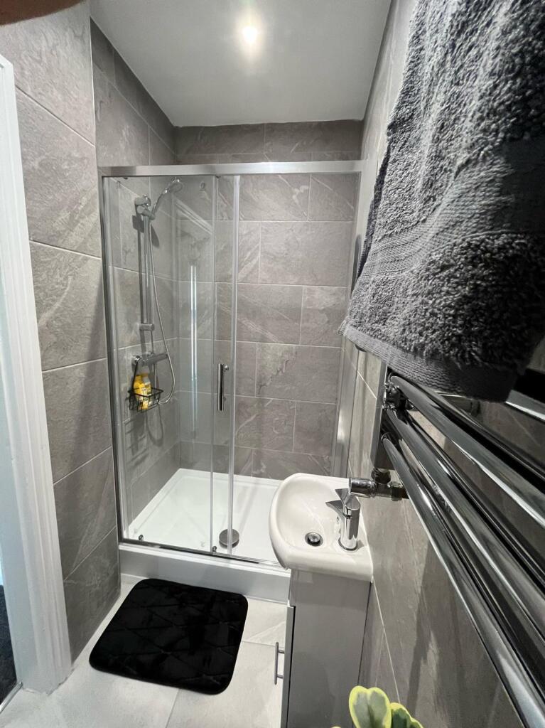 Modern bathroom featuring a sleek glass shower,...