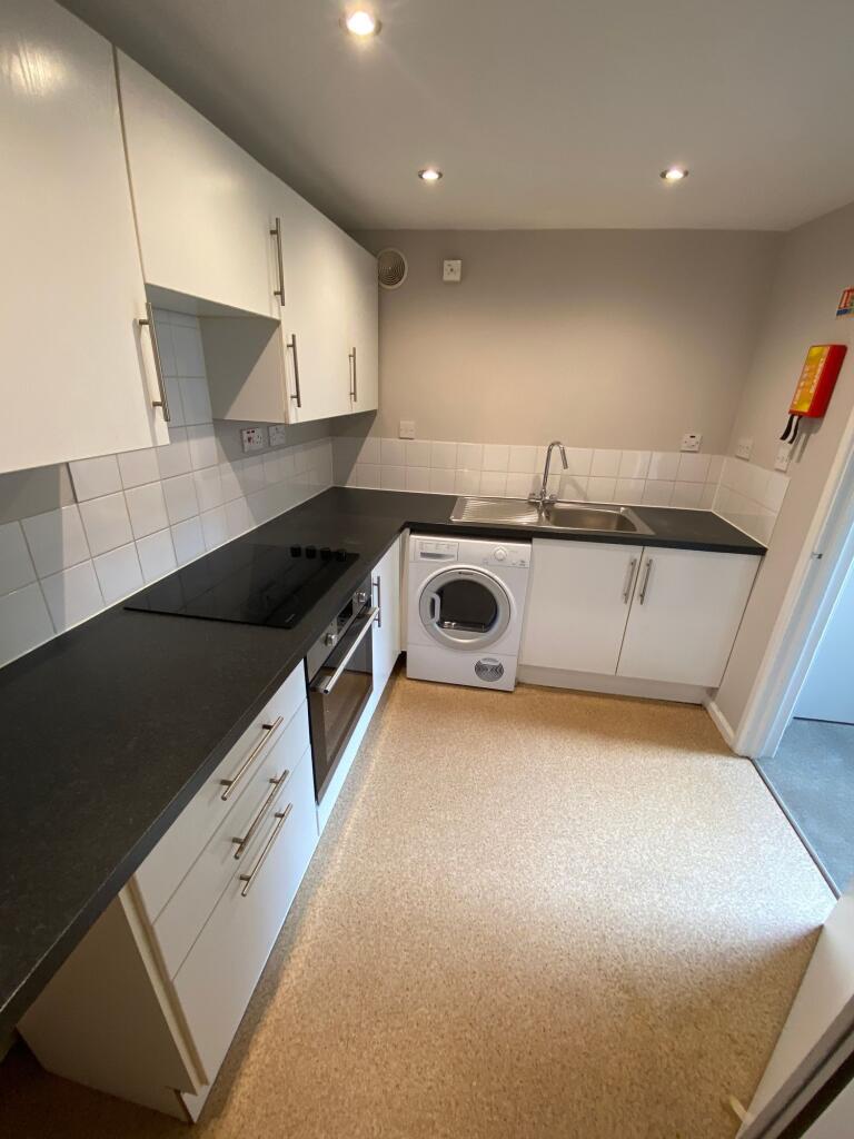 Modern and tidy kitchen featuring sleek black c...
