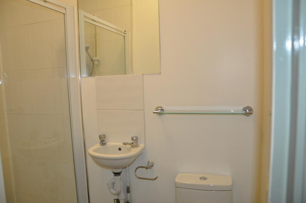 A tidy and functional bathroom with a shower, p...