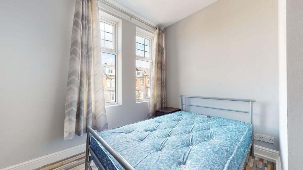 Bright and airy bedroom featuring large windows...