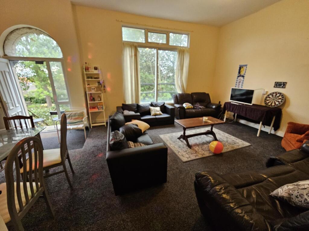 A spacious and well-lit contemporary living roo...