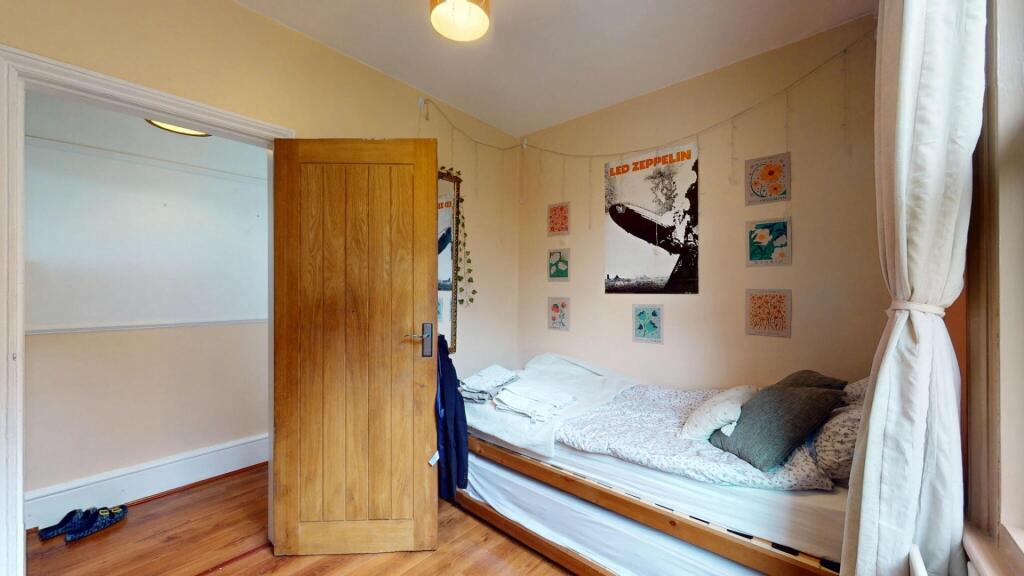 A cozy single bedroom featuring a neatly made s...