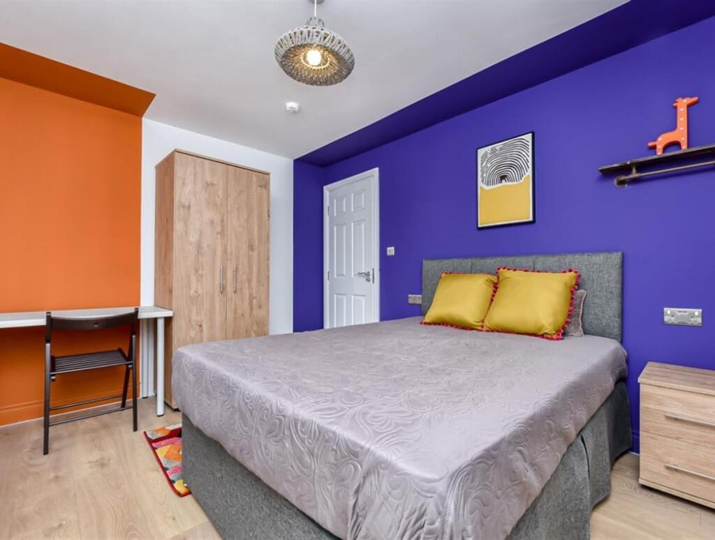 A bright and colorful double bedroom featuring ...