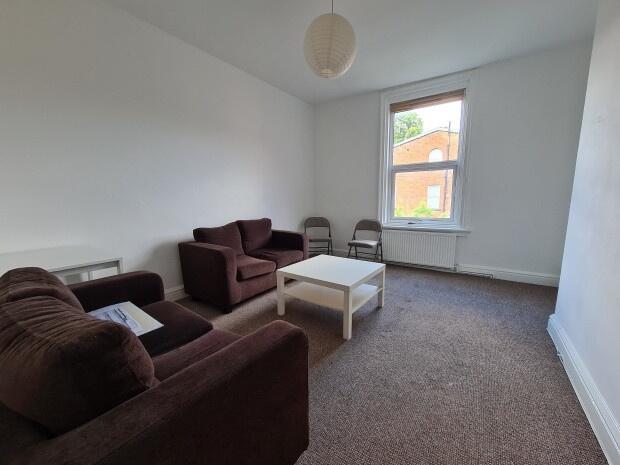 A spacious and tidy living room featuring comfo...