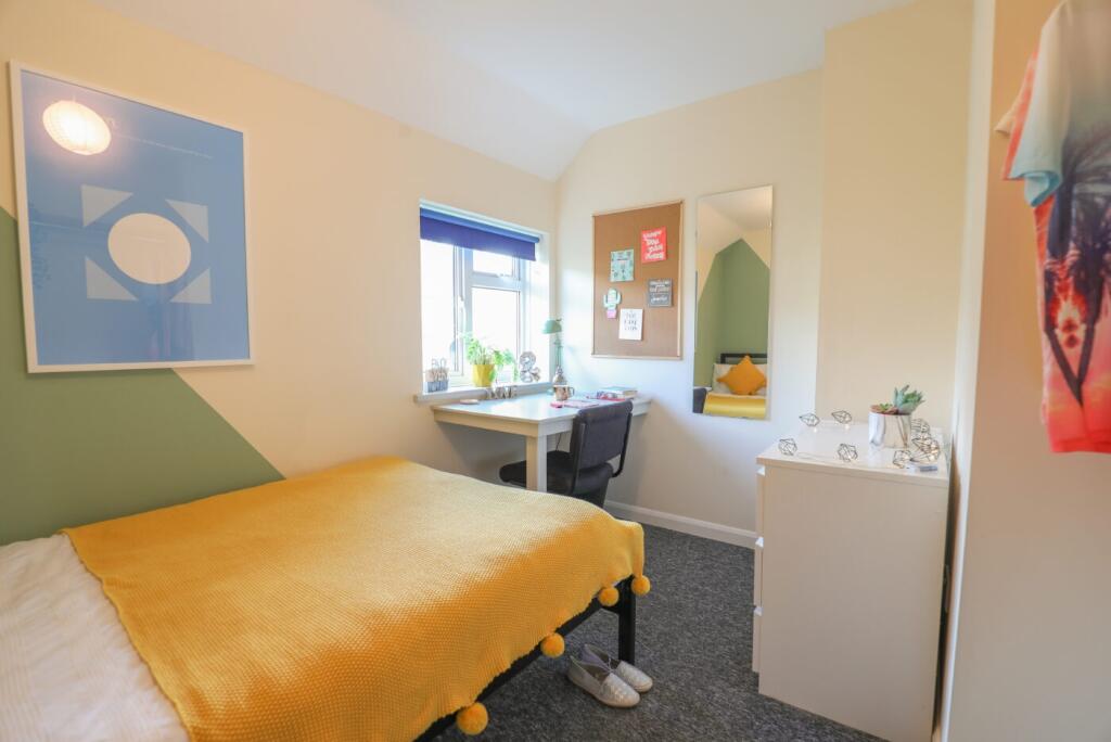 Bright and welcoming bedroom featuring a cozy b...
