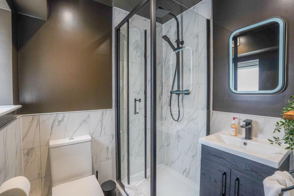 Modern bathroom featuring a walk-in shower with...