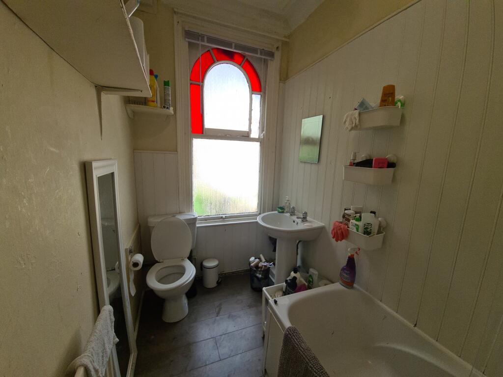 A well-maintained bathroom featuring a bathtub,...