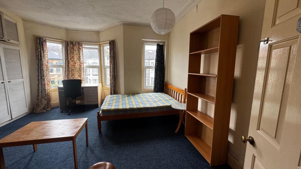 Bright single bedroom featuring three large win...