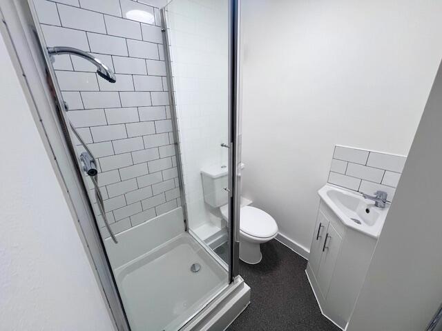 Compact and modern bathroom featuring a glass-e...