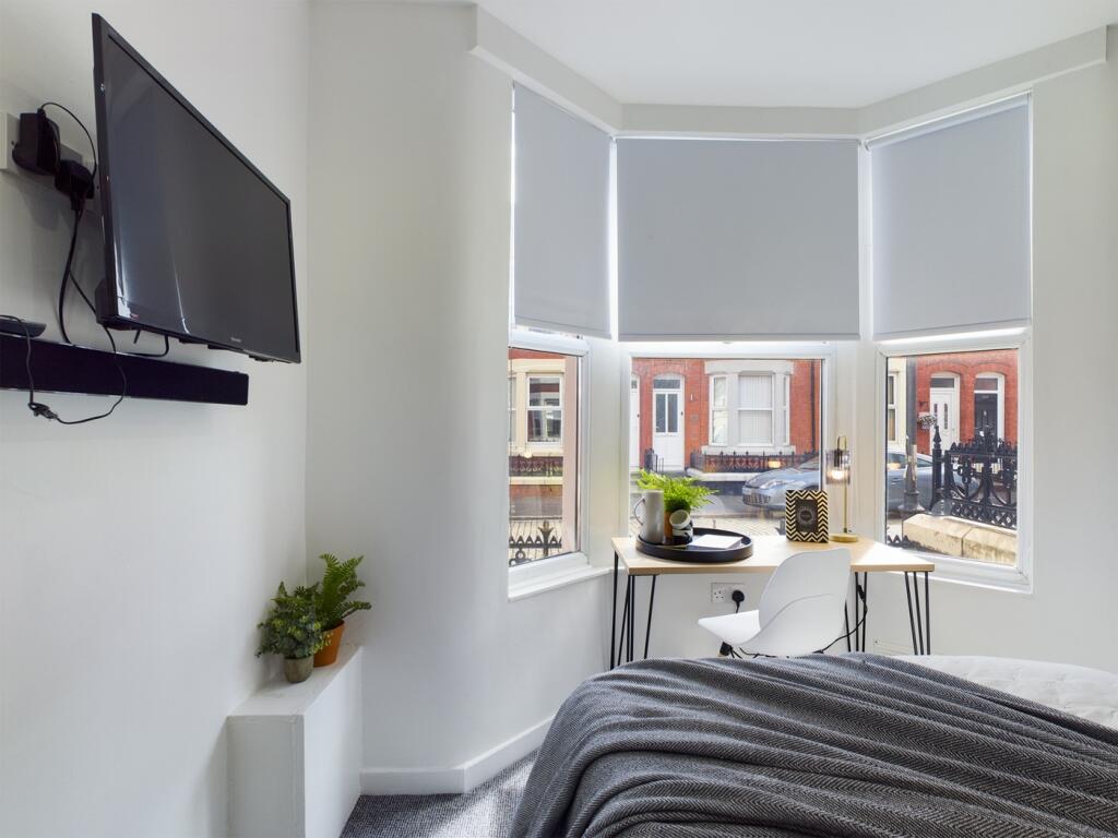 A bright and inviting double bedroom with large...