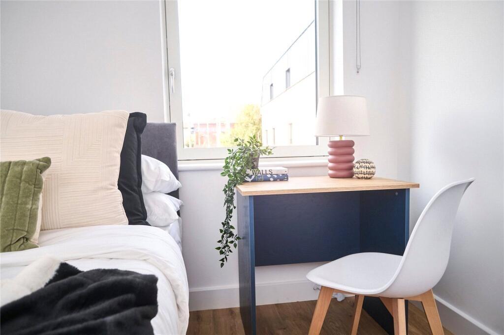 A bright and cozy single bedroom featuring a ne...