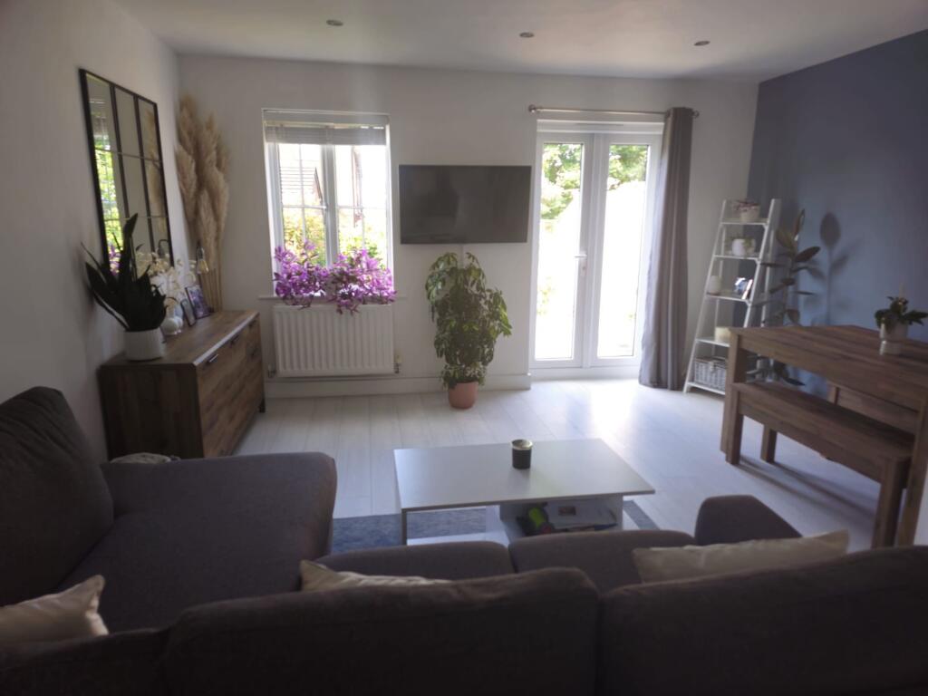 A bright and contemporary living room featuring...