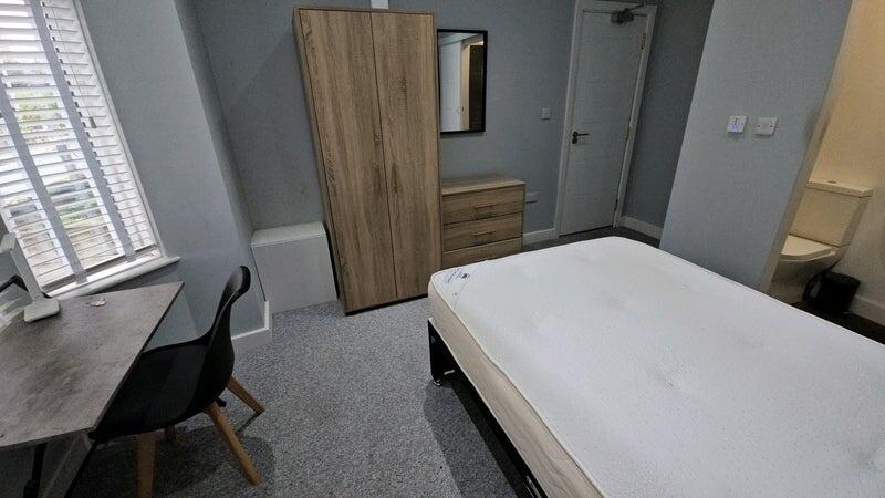 A cozy double bedroom featuring a large window ...