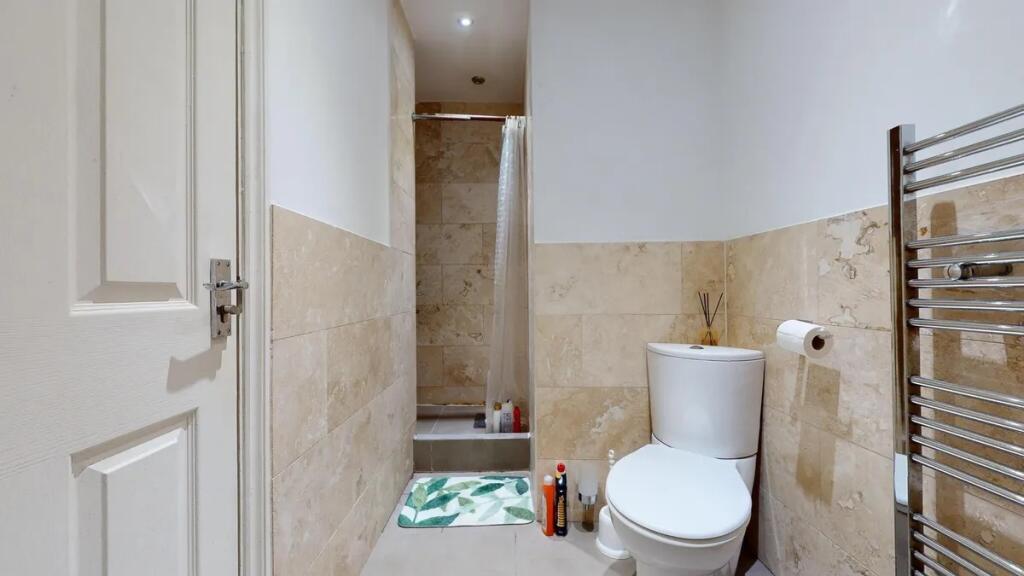 A modern bathroom featuring beige tiled walls a...